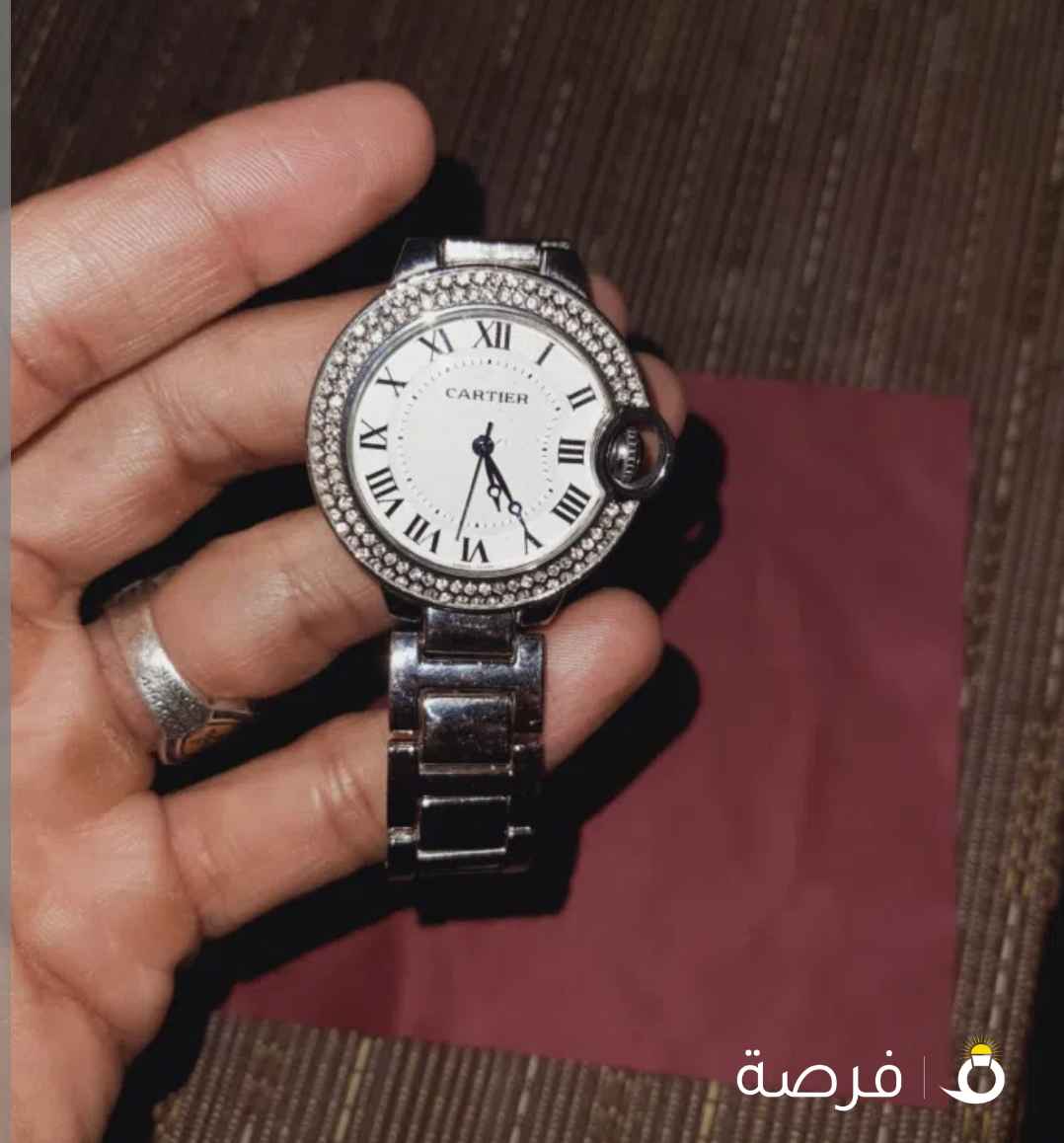 ساعه كارتير ⁦⁦Cartier⁩⁩، وخصوصًا موديل ⁦⁦Ballon⁩⁩ ⁦⁦Bleu⁩⁩ المعروف بالتاج الدائري الجانبي والأرقام الرومانية.